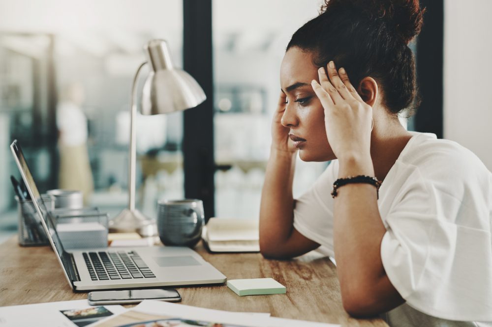 Shot of a young businesswoman looking stressed while using a laptop in her home office
